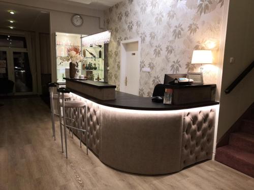 a bar in a hotel lobby with a counter at Hotel Forras in Komárom
