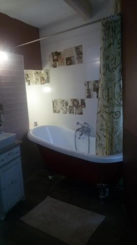 a bath tub with a shower curtain in a bathroom at Casal Annunzia Studio in Tarxien