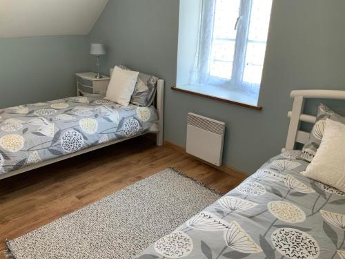 une chambre avec deux lits et une fenêtre dans l'établissement Vue sur le lac, à Huelgoat