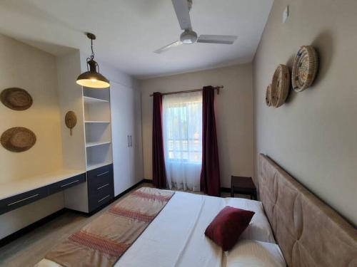 sypialnia z dużym łóżkiem i oknem w obiekcie Elegant 1 Bedroom Condo Near Vipingo Ridge Golf Resort w mieście Kilifi