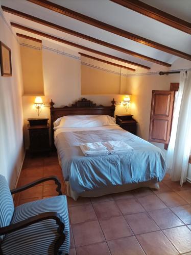 1 dormitorio con 1 cama, 2 mesas y 1 silla en LA PENSION DE DOÑA ANITA, en San Antonio de Requena