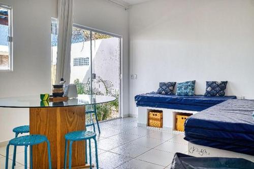 um quarto com uma cama, uma mesa e cadeiras em Mykonos Residence em São Miguel do Gostoso