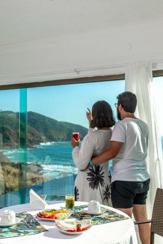 Ein Mann und eine Frau machen ein Foto vom Meer in der Unterkunft Hotel Pousada Brava Club in Búzios