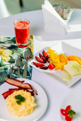 ein weißer Tisch mit einem Teller mit Essen darauf in der Unterkunft Hotel Pousada Brava Club in Búzios