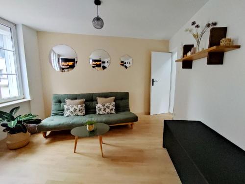 a living room with a green couch and a table at My Duplex House Trouville in Trouville-sur-Mer