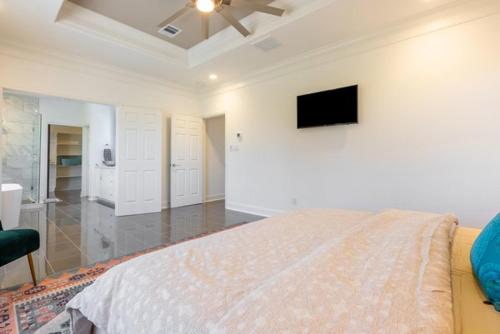 a bedroom with a bed and a television on the wall at Cute Cozy house close to major sporting events and restaurants in Houston