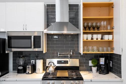 a kitchen with a stove top and a microwave at Cute Cozy house close to major sporting events and restaurants in Houston