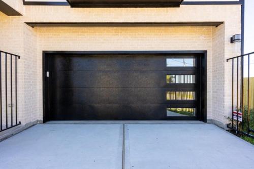 a garage with a large black garage door at Cute Cozy house close to major sporting events and restaurants in Houston