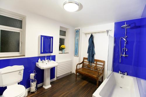 a blue and white bathroom with a toilet and a sink at Seafarer's View - 6 bedroom townhouse in Cowes, parking & seaviews. in Cowes