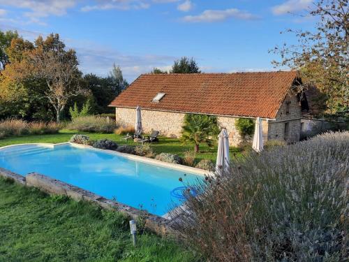 une maison avec une piscine et un bâtiment dans l'établissement Gîte de l'Ane Papillon-3 chb- piscine-jardin, à Saint-Cirq-Souillaguet