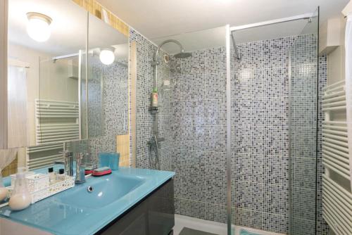 ein Badezimmer mit einem blauen Waschbecken und einer Dusche in der Unterkunft Appartement Indépendant en maison à 15 MIN de LYON in Saint-Symphorien-dʼOzon