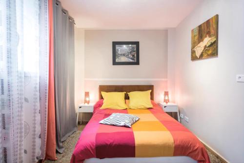 a bedroom with a bed with a colorful blanket at Appartement Indépendant en maison à 15 MIN de LYON in Saint-Symphorien-dʼOzon
