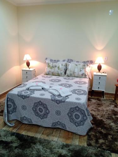 a bedroom with a bed and two night stands at Chale Aroma da Serra in Monte Verde