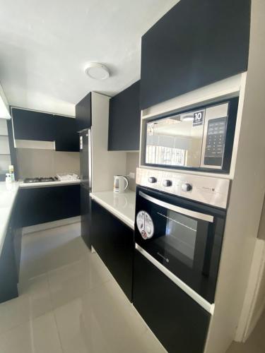 a kitchen with a stove and a microwave at Departamento primer piso cercano a Alameda in Constitución