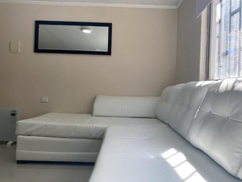a white couch in a living room with a mirror at Departamento primer piso cercano a Alameda in Constitución