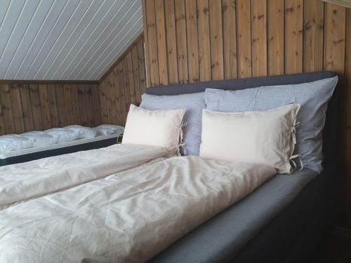 a large bed with white sheets and pillows at Grostul in Lifjell