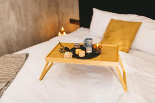 a tray on a bed with a table on it at GRAPHITE Затишні апартаменти біля Центру з окремою спальнею і кухнею-вітальнею in Ternopilʼ