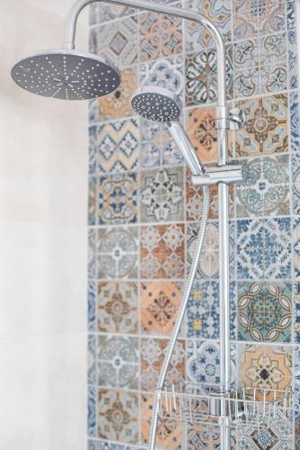 a shower in a bathroom with tiles on the wall at Hostal El Perelló, Valencia in El Perelló