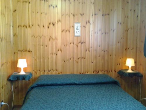a bedroom with a bed with two lamps on it at Hotel Villa Stella in Cascia