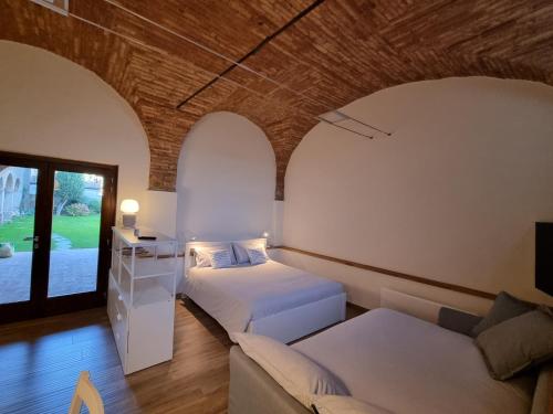 a hotel room with two beds and a couch at DIMORA DESENZANI - Lago di Garda in Esenta