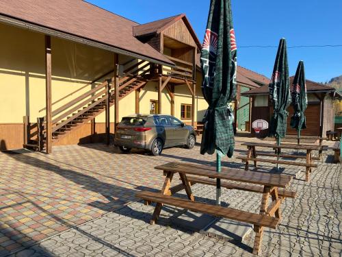 a group of picnic tables and umbrellas in front of a building at Relax Centrum Gól in Loučná nad Desnou