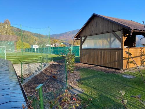 a small building with a fence in a yard at Relax Centrum Gól in Loučná nad Desnou