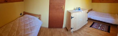 a bedroom with two beds and a dresser and a door at Vikendica kraj Dunava Oaza in Banoštor