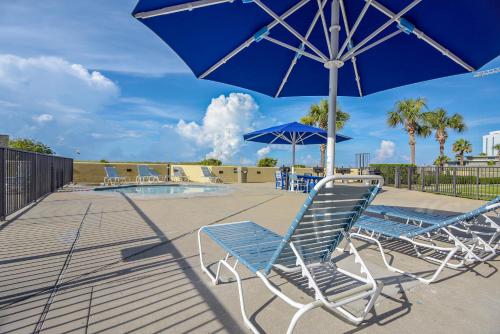 a group of chairs and an umbrella next to a pool at Phoenix 6 Unit 1015 in Orange Beach