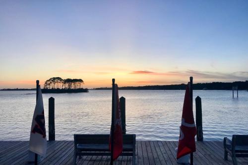 a dock with two benches and flags in front of the water at Phoenix 6 Unit 1015 in Orange Beach