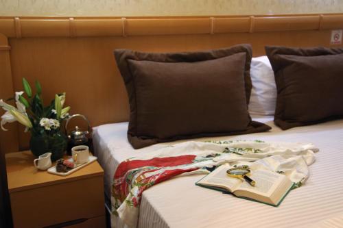 a bed with an open book and a bible on it at Stargate Hotel&Spa in Korfez
