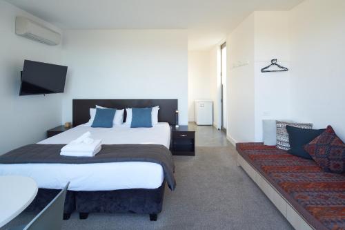 a bedroom with a large bed and a couch at Lakeview Studio A - Lake Tekapo in Lake Tekapo