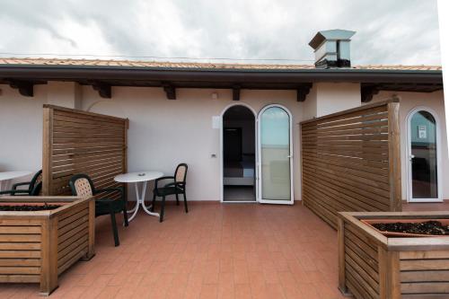 a patio with wooden doors and a table and chairs at Hotel Villa Augustea in Rimini
