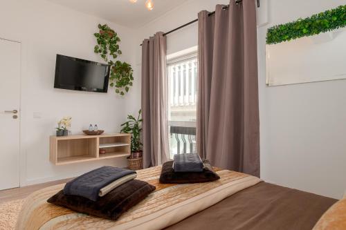 a bedroom with a bed with two pillows on it at Avenue View Rooms in Porto