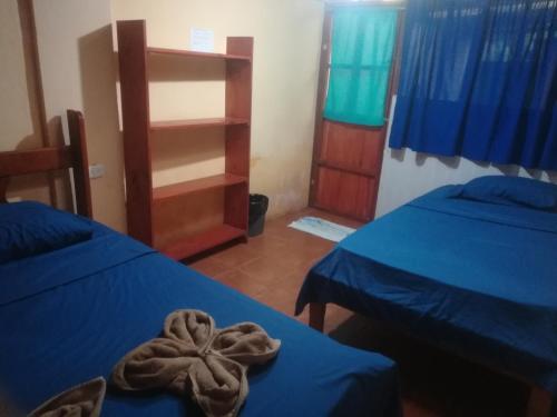 a room with two beds and a towel on a table at Jacobin Hostel & Cabins in Drake