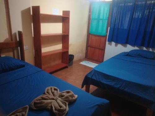 a room with two beds and a towel on the bed at Jacobin Hostel & Cabins in Drake