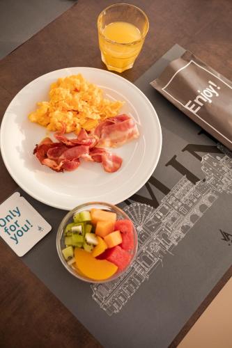 a table with a plate of breakfast food and a glass of orange juice at Hotel Villa Augustea in Rimini