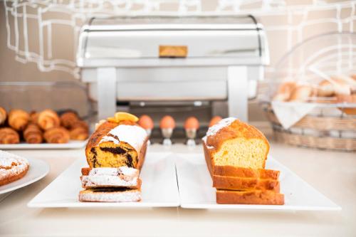 a counter with three plates of bread and pastries at Hotel Villa Augustea in Rimini