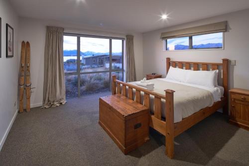 a bedroom with a bed and a large window at Number 8 - Lake Tekapo in Lake Tekapo