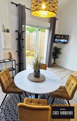 a dining room with a white table and chairs at Cosy Normandy - 02 in Bois-Jérôme-Saint-Ouen