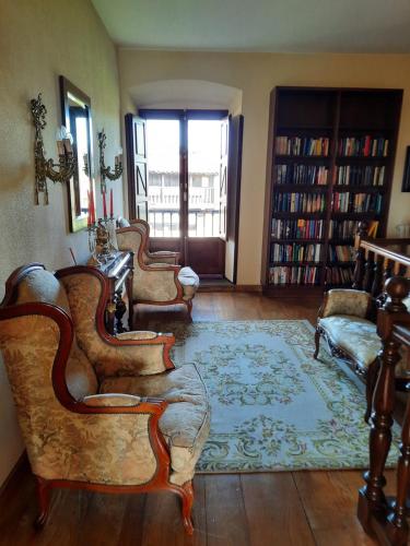a living room with several chairs and a rug at Palacio Marqués Vega de Anzo - Villa de campo sXVII in Siero