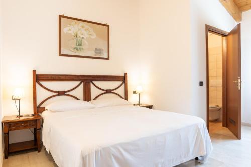a bedroom with a bed with white sheets and a picture on the wall at Agriturismo Cà Nuova in Minerbio