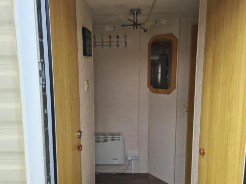 a hallway with a bathroom with a toilet and a window at 6 Berth on Seaview (Fanfare) in Ingoldmells