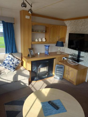 a living room with a couch and a fireplace at 6 Berth on Seaview 3 bedrooms Fanfare in Ingoldmells