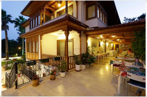 a balcony of a house with tables and chairs at Ayka Hotel in Akyaka