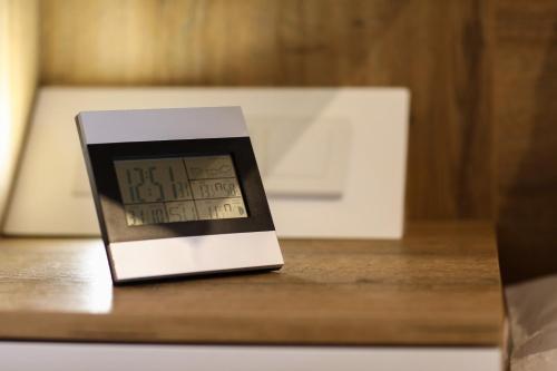a clock sitting on top of a wooden table at Apartman 5 plus - Vila Nova in Jahorina