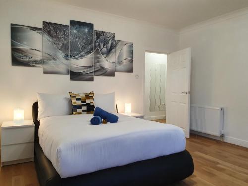 a bedroom with a large white bed in a room at Glasgow Comfortable and Modern 3 Bedroom Mid Terraced Villa in Glasgow