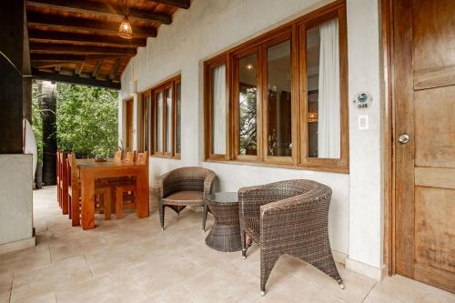a patio with wicker chairs and a table and a door at Playa Venao Hotel Resort in Playa Venao