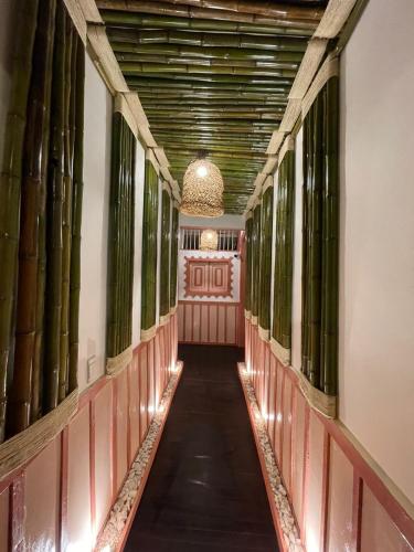 a corridor of a building with a hallway with bamboo at Mahalo Hostel in Salento