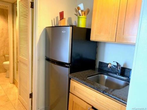 une cuisine avec un réfrigérateur en acier inoxydable et un évier dans l'établissement Royal Garden Waikiki Studio, à Honolulu