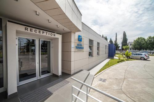 a hospital building with a door and a car parked at Hotel Terminus in Podgorica